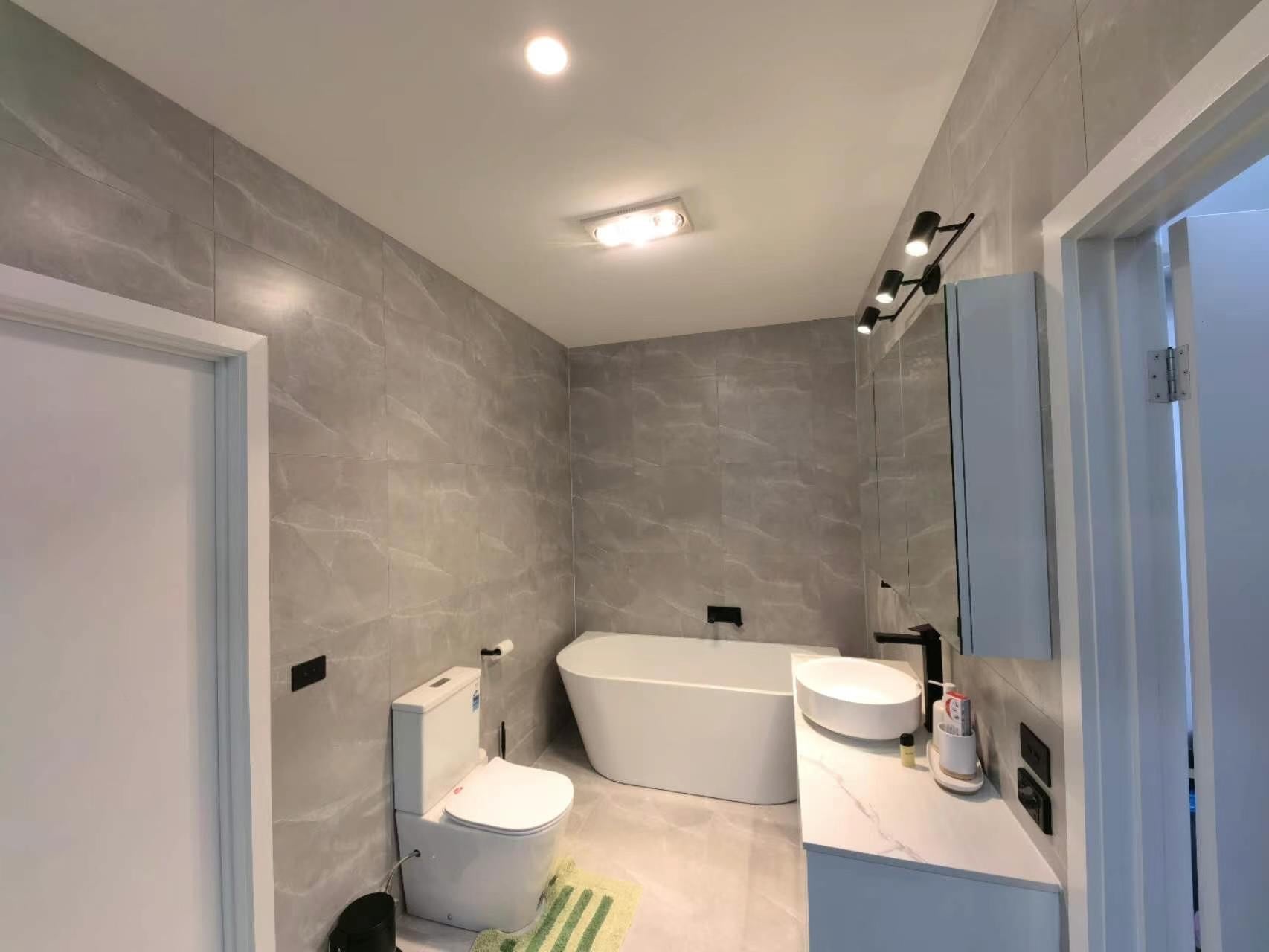 Bathroom renovation with freestanding bath and grey tiling