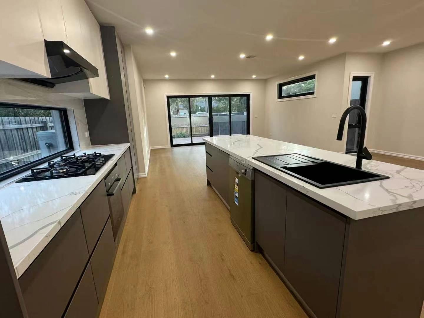 Kitchen renovation with dark cabinetry and stone benchtops