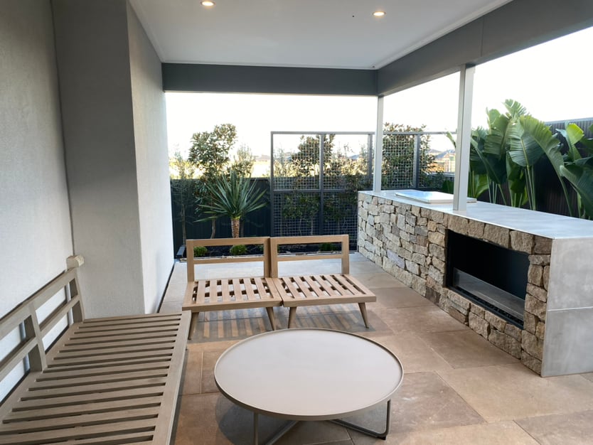 Covered outdoor living area with stone fireplace