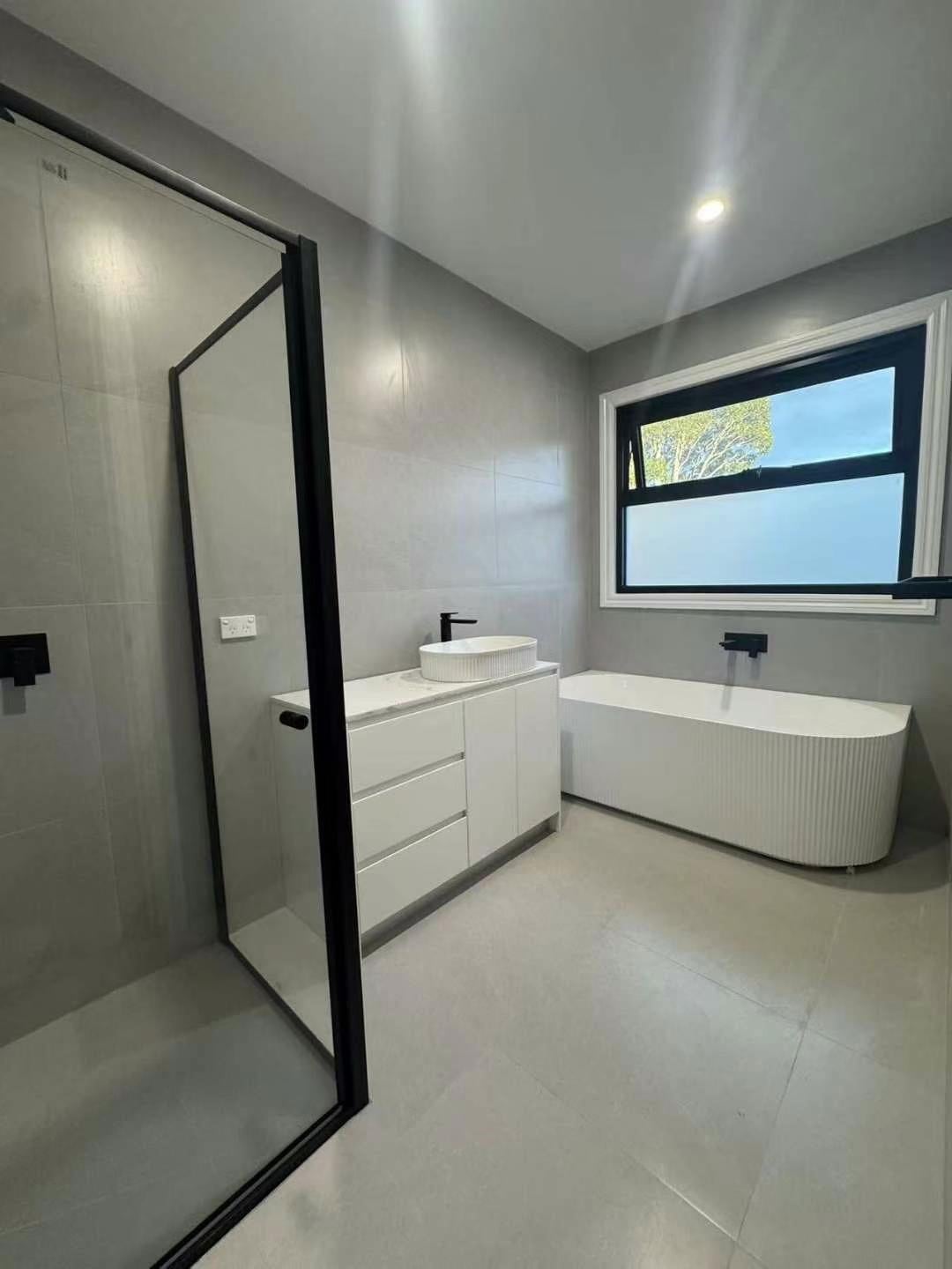 Bathroom with freestanding bath and framed shower