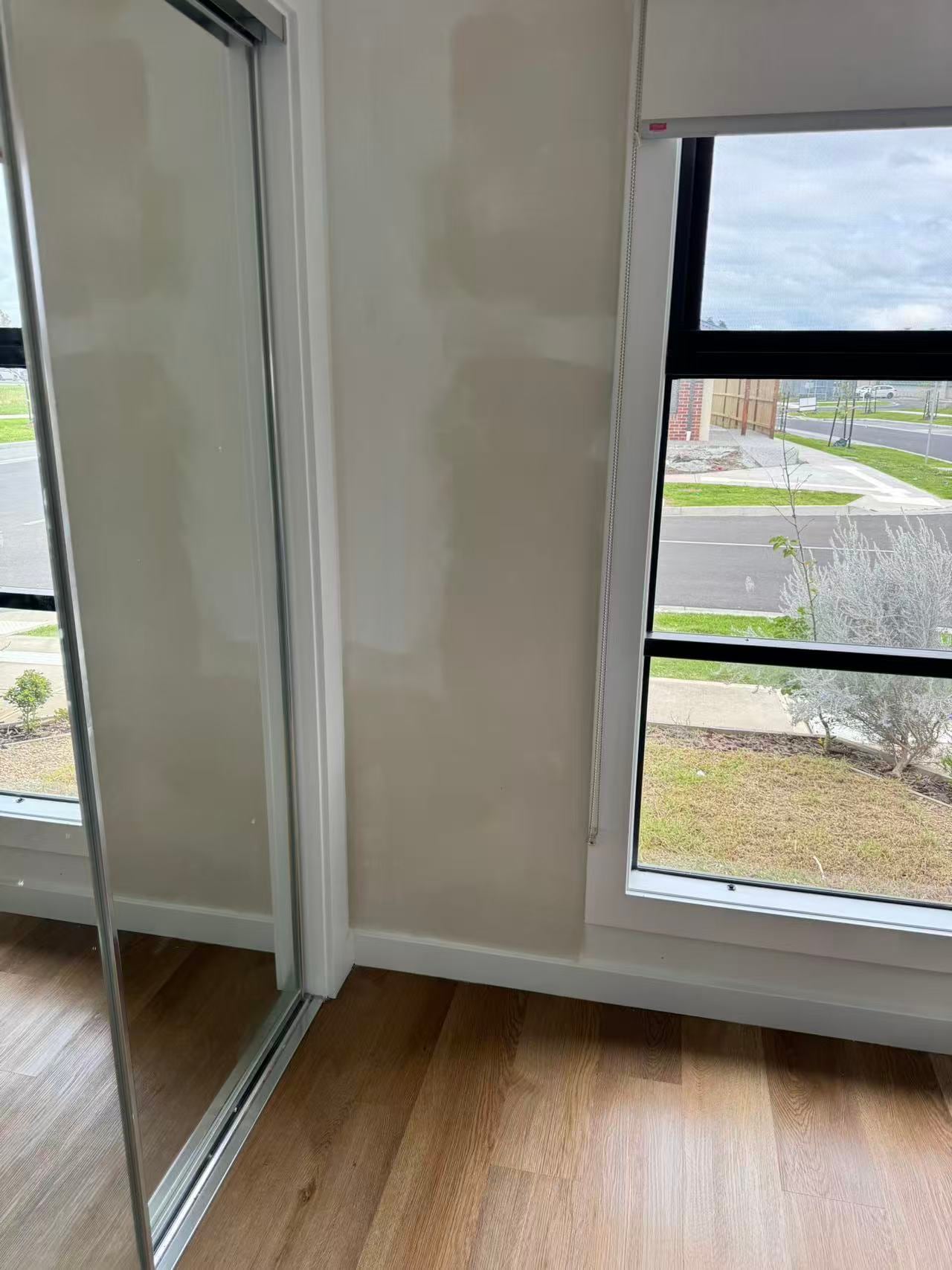 Repaired wall beside a mirrored built-in wardrobe